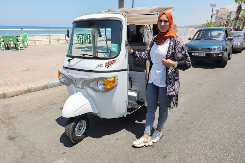 Hala Mohammed al-Yaman, Lebanese mother and tuk-tuk driver, stands next to her tuk-tuk at the corniche in the port city of Sidon, Lebanon June 28, 2022.  REUTERS / Aziz Taher
