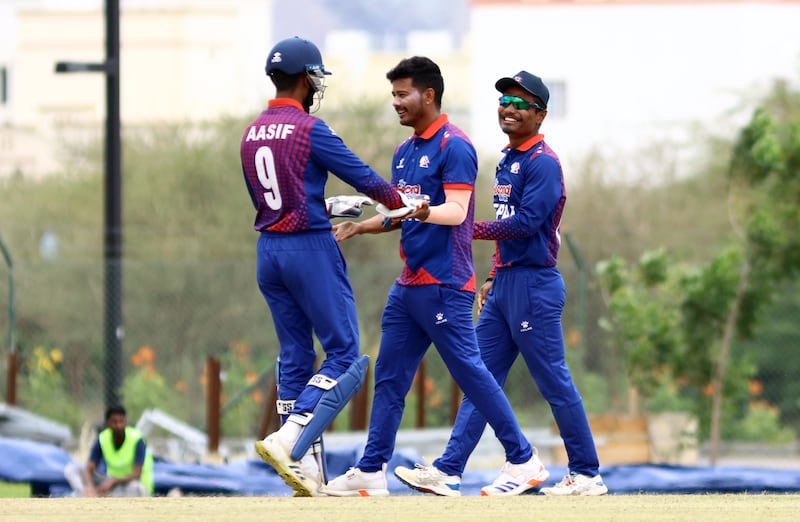 Avinash Bohora of Nepal, centre, who took 3-29, celebrates after claiming a wicket.