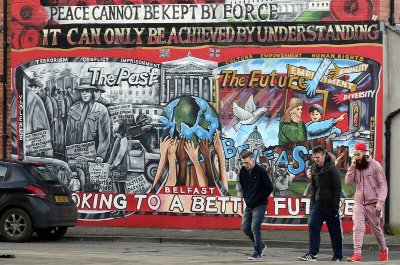 Men walk past a mural on the Newtownards Road in Belfast on January 25, 2017.
Northern Ireland will hold snap elections on March 2, 2017 in a bid to resolve its worst political crisis in years after the power-sharing executive collapsed on January 16, 2017. Under the rules of the power-sharing government, which was set up as part of the peace process, the January 10, 2107 resignation of Deputy First minister Martin McGuinness, of Sinn Fein, forced First Minister Arlene Foster, from the rival Democratic Unionist Party, to also step down. / AFP PHOTO / Paul FAITH