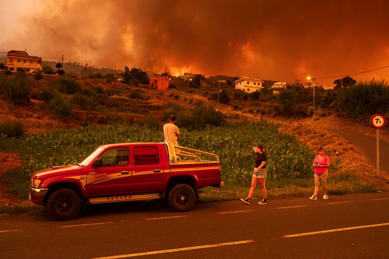 Residents try to reach their homes in Benijos village as fire closes in on La Orotava, Tenerife. AP