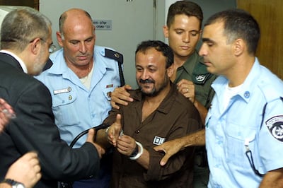 Marwan Barghouti, centre, pictured at Tel Aviv District Court on August 14, 2002. From his jail cell, he has managed to establish widespread support and loyalty among Palestinian society – even among rival political and paramilitary factions. Getty