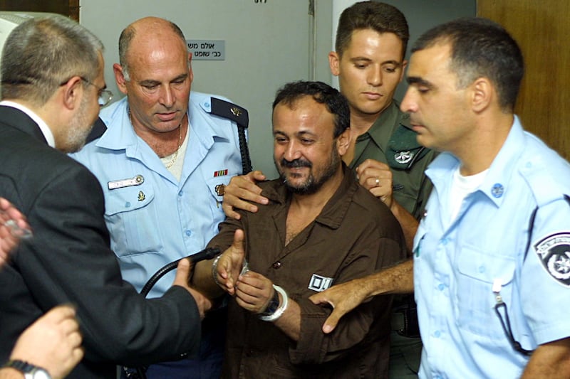 Barghouti, the West bank chief of Yasser Arafat's Fatah movement, is greeted by his lawyer Jawad Boulos in the courtroom on the opening day of his court case in Tel Aviv, in August 2002. Getty Images