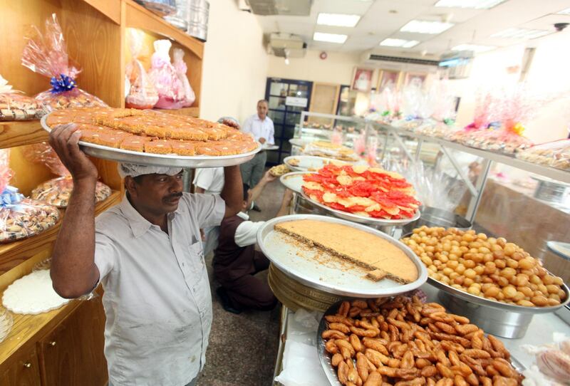 September 9, 2010/  Abu Dhabi /  Abdul Sharafudeen from the Al Saada Bakery brings out freshly backed arabic sweets to be sold the day before Eid-al-Fitr on of the busiest day of the year for the bakery September 9, 2010. (Sammy Dallal / The National)
