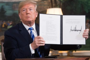 TOPSHOT - US President Donald Trump signs a document reinstating sanctions against Iran after announcing the US withdrawal from the Iran Nuclear deal, in the Diplomatic Reception Room at the White House in Washington, DC, on May 8, 2018. / AFP PHOTO / SAUL LOEB