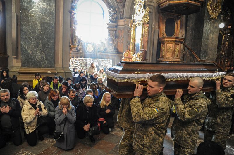 Ukrainian servicemen carry a coffin during a funeral in Lviv, Ukraine. EPA