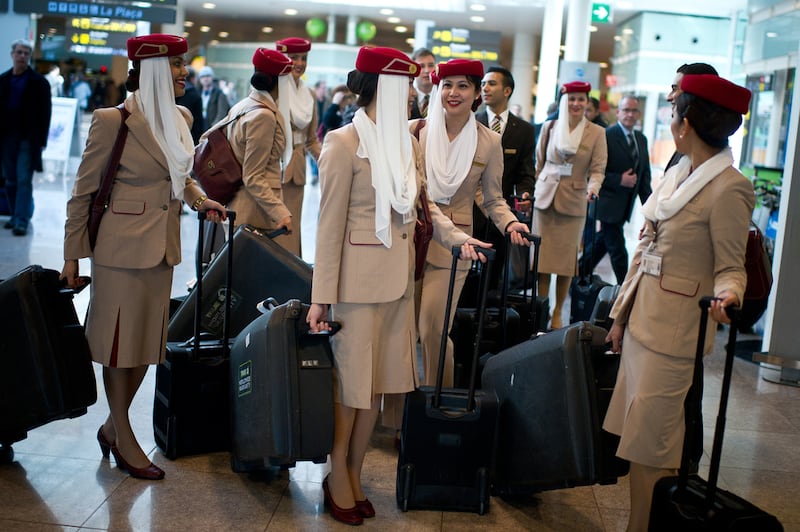 Emirates cabin crew in the airline's brown, white and red uniforms. Getty