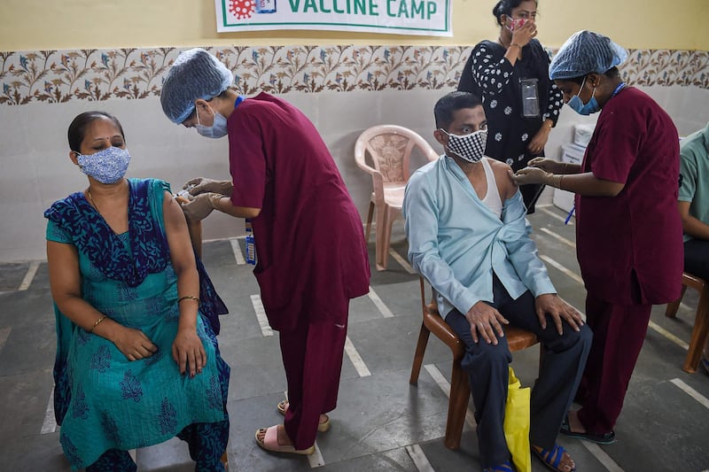 Residents get inoculated with a dose of the Covishield, AstraZeneca-Oxford's Covid-19 coronavirus vaccine, at a vaccination centre in the Dharavi slums in Mumbai on June 29, 2021. / AFP / Punit PARANJPE
