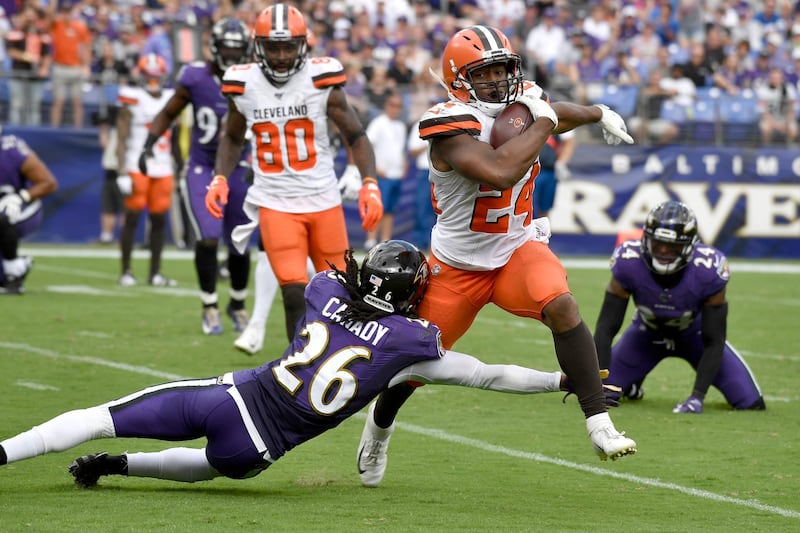Cleveland Browns running back Nick Chubb (24) avoids a tackle from Baltimore Ravens cornerback Maurice Canady (26) before scoring a touchdown run during the second half of an NFL football game Sunday, Sept. 29, 2019, in Baltimore. (AP Photo/Brien Aho)