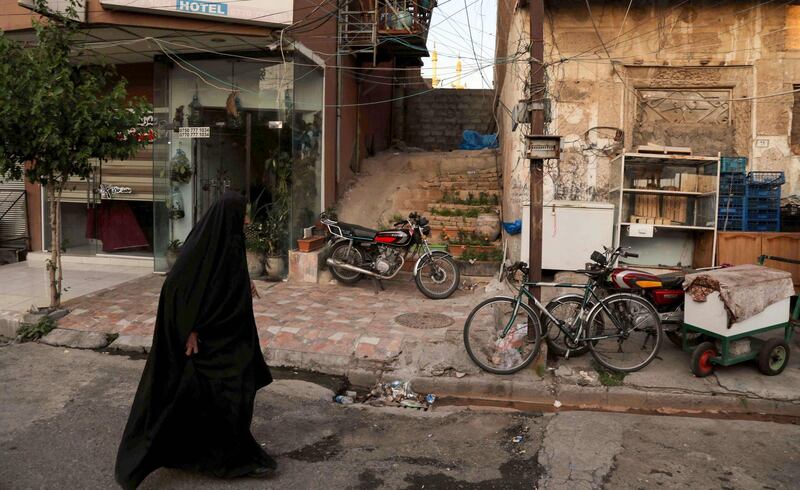 An Iraqi Kurdish woman walks in an empty street in Erbil, the capital of the northern Iraqi Kurdish autonomous region, amid a lockdown to combat the spread of the coronavirus.  AFP