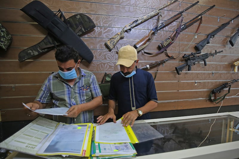 Employees review customers' authorisation documents at a gun shop in the Iraqi capital. AFP