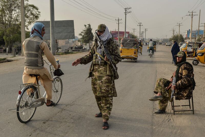 Taliban fighters check travellers on a road in Kunduz, two days after a deadly suicide bombing at a mosque in the city for which ISIS-K claimed responsibility. AFP