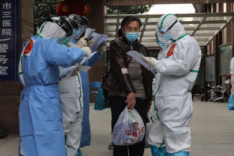 Medical staff check information as patients infected by the coronavirus leave from Wuhan No 3 Hospital to Huoshenshan Hospital in Wuhan.  AFP