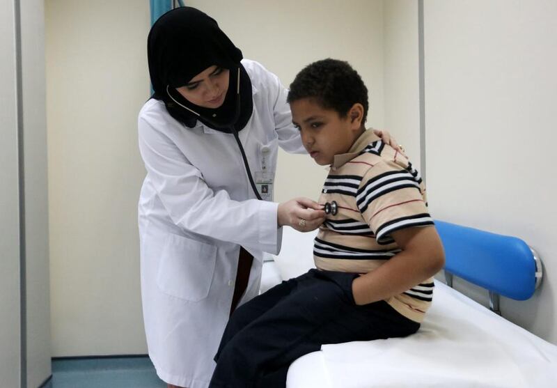Dr Amal Al Saberi, a second-year family medicine resident, examines 10-year-old Yousef Mamdouh at the Nad Al Hamar health centre in Dubai. Christopher Pike / The National
