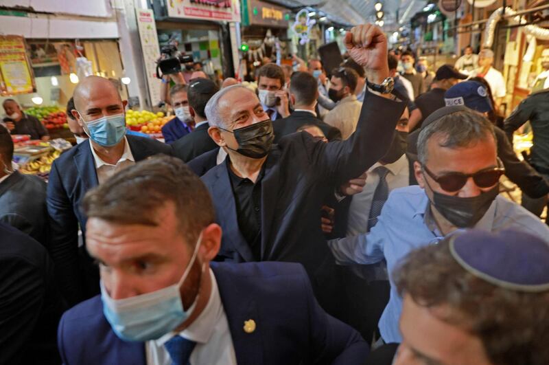 Israeli Prime Minister Benjamin Netanyahu greets supporters as he tours the Mahane Yehuda market in Jerusalem. AFP