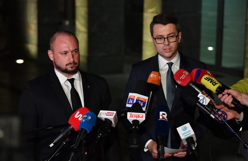 Polish government spokesman Piotr Mueller and security chief Jacek Siewiera at the meeting in Warsaw. EPA