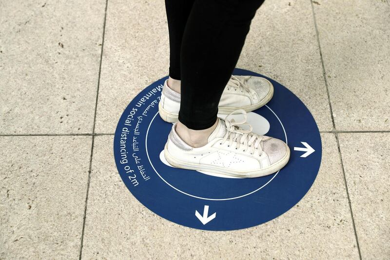 A passenger stands on a sign to keep distance at Dubai International Airport on April 27, 2020. Reuters