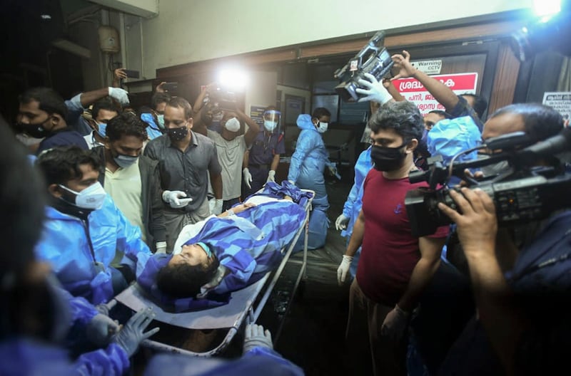 An injured passenger is wheeled into Medical College Hospital in Calicut after an Air India Express flight skidded off the runway while landing at Kozhikode International Airport. AP Photo