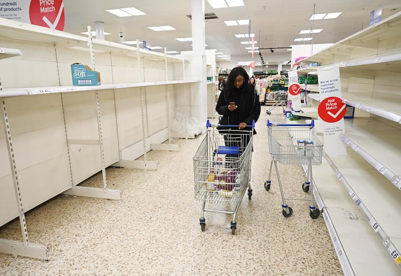 epa08295925 A woman pushes her trolley down empty toilet roll shelves in a supermarket in London, Britain, 15 March 2020. It has been reported that UK supermarkets have appealed to customers not to stockpile food due to coronavirus. Several European countries have closed borders, schools as well as public facilities, and have cancelled most major sports and entertainment events in order to prevent the spread of the SARS-CoV-2 coronavirus causing the Covid-19 disease.  EPA/NEIL HALL