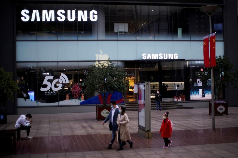 FILE PHOTO: People wears masks in front a Samsung Store at a main shopping area as the country is hit by an outbreak of the new coronavirus in downtown Shanghai, China February 21, 2020. REUTERS/Aly Song/File Photo  GLOBAL BUSINESS WEEK AHEAD