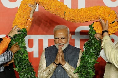 Prime Minister Narendra Modi gestures as he is presented with a garland by BJP leaders in New Delhi after winning India's general election. Reuters