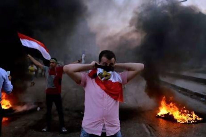 An Egyptian protester covers his face with his national flag during clashes between supporters of the Muslim Brotherhood and security forces in Cairo.