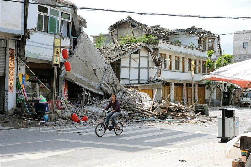 In this photo released by China's Xinhua News Agency, a local resident bicycles in front of collapsed houses after an earthquake struck in Lushan County, Ya'an City, in southwest China's Sichuan Province, Saturday, April 20, 2013. A powerful earthquake struck the steep hills of China's southwestern Sichuan province Saturday morning, leaving at least 160 people dead and more than 6,700 injured. (AP Photo/Xinhua, Jin Xiaoming) NO SALES *** Local Caption ***  China Earthquake.JPEG-0dad7.jpg