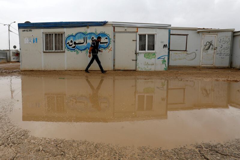 A Syrian refugee walks during rainy weather at the Al Zaatari refugee camp in the Jordanian city of Mafraq, near the border with Syria December 18, 2016. REUTERS/Muhammad Hamed - RTX2VJDU