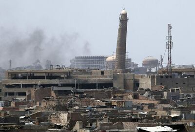 (FILES) This combination of pictures created on January 10, 2018 shows a general view (L) of smoke rising next to the Al-Hadba minaret at the Al-Nuri Mosque in Mosul's Old City on June 18, 2017. AFP