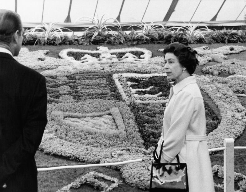 Queen Elizabeth and her husband Prince Philip viewing the carpet bedding of the Royal Coat of Arms in 1975. Getty Images
