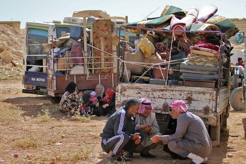 Syrian refugees gather next to their vehicles getting ready to cross into Syria from the eastern Lebanese border town of Arsal, Lebanon, on June 28, 2018. Stringer / AFP