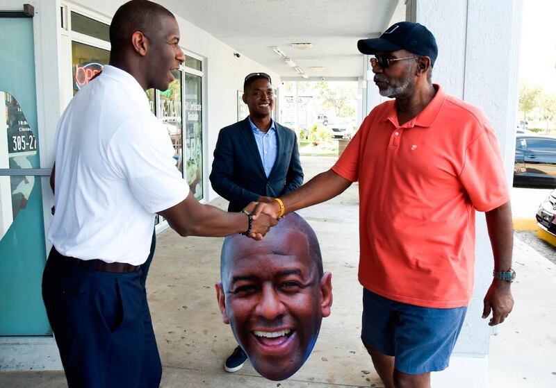 Democratic Candidate for Florida Governor, Mayor Andrew Gillum, left, greets lunchtime supporters at Chick N' Wings, during his 'Bring It Home' Bus Tour in Miami, Florida.  AFP