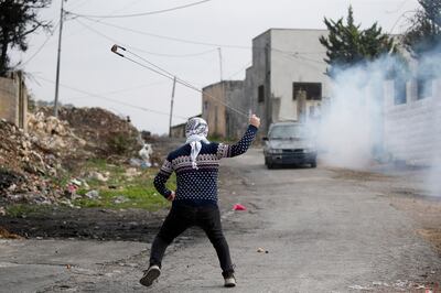 A Palestinian protester prepares to sling a stone during clashes with Israeli soldiers in Kafr Qaddum village, near the West Bank city of Nablus. The clashes followed a protest against Israeli settlements in the area.   EPA 