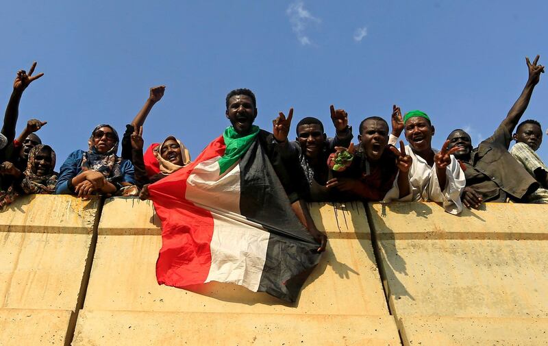 Civilians hold their national flag as they celebrate the signing of the Sudan's power sharing deal, that paves the way for a transitional government, and eventual elections, following the overthrow of long-time leader Omar al-Bashir, in Khartoum, Sudan, August 17, 2019. REUTERS/Mohamed Nureldin Abdallah