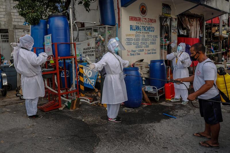 Health workers are disinfected by Ian Arcilla (R) after finishing their morning rounds to people infected or suspected to be infected with COVID-19 at a townhall in Manila, Philippines. Four volunteer health workers were nicknamed 'Astronauts' by residents of Village 775, Zone 84 in Manila as they resemble such when donning their protective equipment. The healthcare volunteers conduct home visits twice a day to people infected or suspected to be infected with the novel SARS-CoV-2 coronavirus that causes the COVID-19 disease in one of the densely populated villages in Manila.  EPA