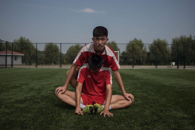 Students stretch following an under-14 training session at the Pyongyang International Football School. Ed Jones / AFP
