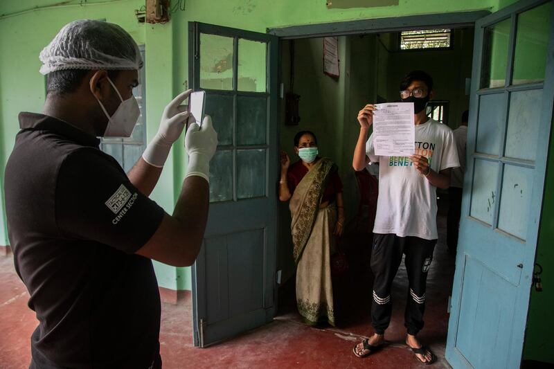 A health worker takes photograph of a patient holding a Covid-19 positive certificate at a hospital in India’s north-eastern city of Guwahati.