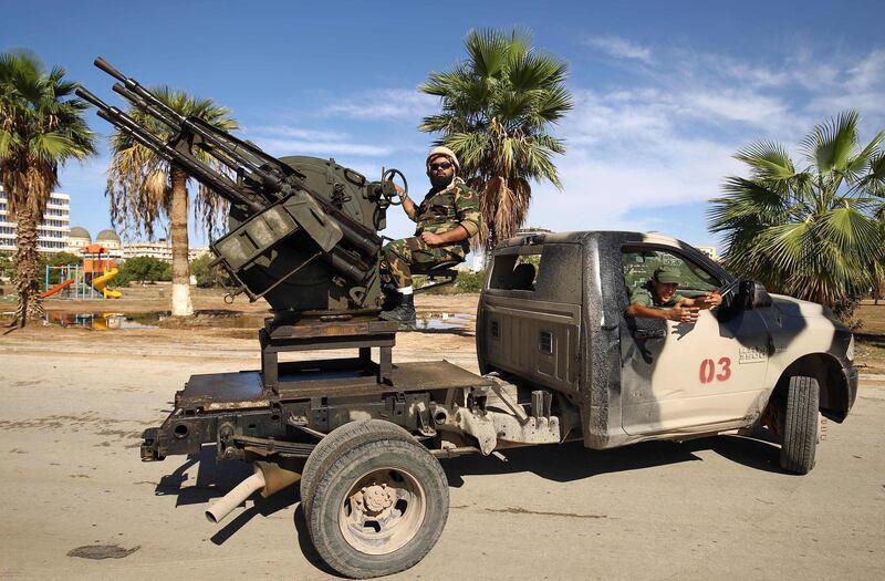 Members of the Libyan security forces loyal to Libyan Strongman Khalifa Haftar man turrets mounted in the back of pickup trucks as they remain on guard duty during the 2018 edition of the Benghazi International Forum and Exhibition of Oil & Gas, in the eastern Libyan city on October 24, 2018.  / AFP / Abdullah DOMA
