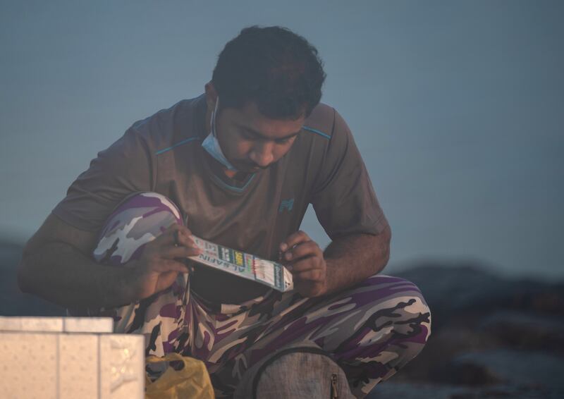 An angler deliberates over which lure to choose.