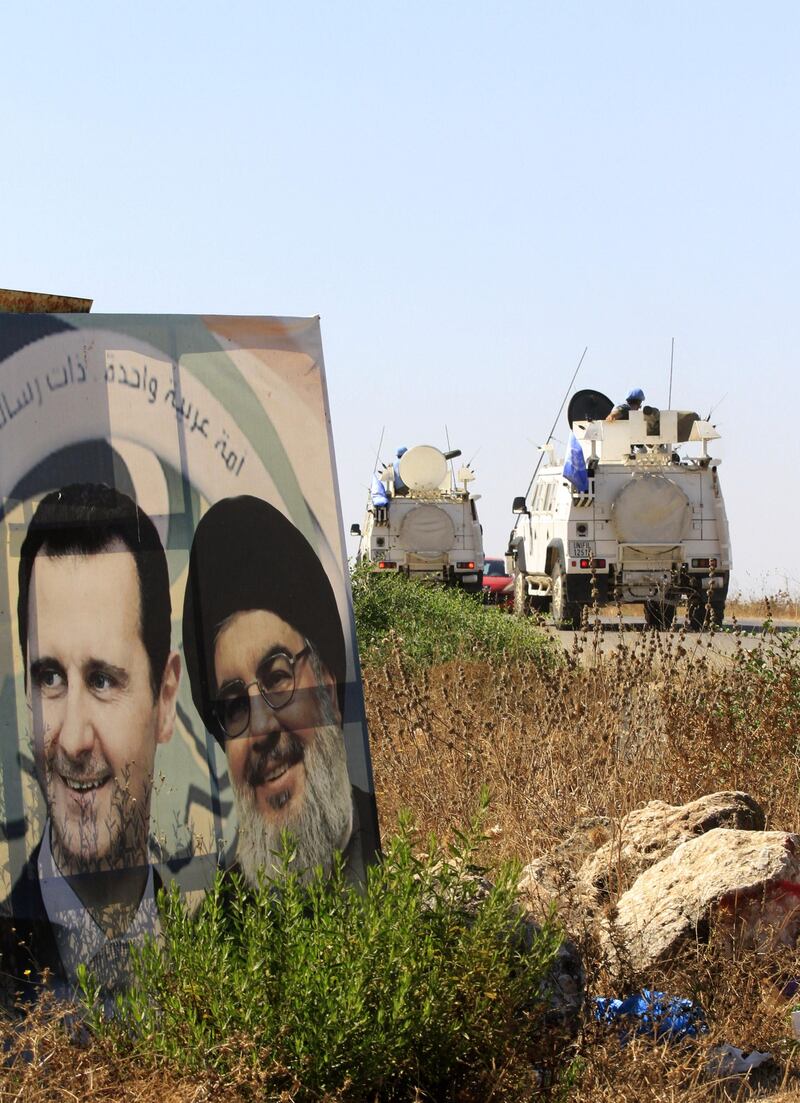 Military vehicles belonging to the United Nations Interim Forces in Lebanon (UNIFIL) drive past posters of the Lebanese Shiiite Hezbollah movement leader Hasan Nasrallah (R) and Syrian President Bashar al-Assad, on a road near the southern Lebanese village of Marjayoun, on August 26, 2019.  Nasrallah yesterday threatened Israel after a "drone attack" on the Lebanese Shiite movement's Beirut stronghold, vowing to "do everything" to thwart future attacks.
Hezbollah, considered a terrorist organisation by Israel and the United States, is a major political actor in Lebanon and a key government backer in war-torn Syria. / AFP / Mahmoud ZAYYAT
