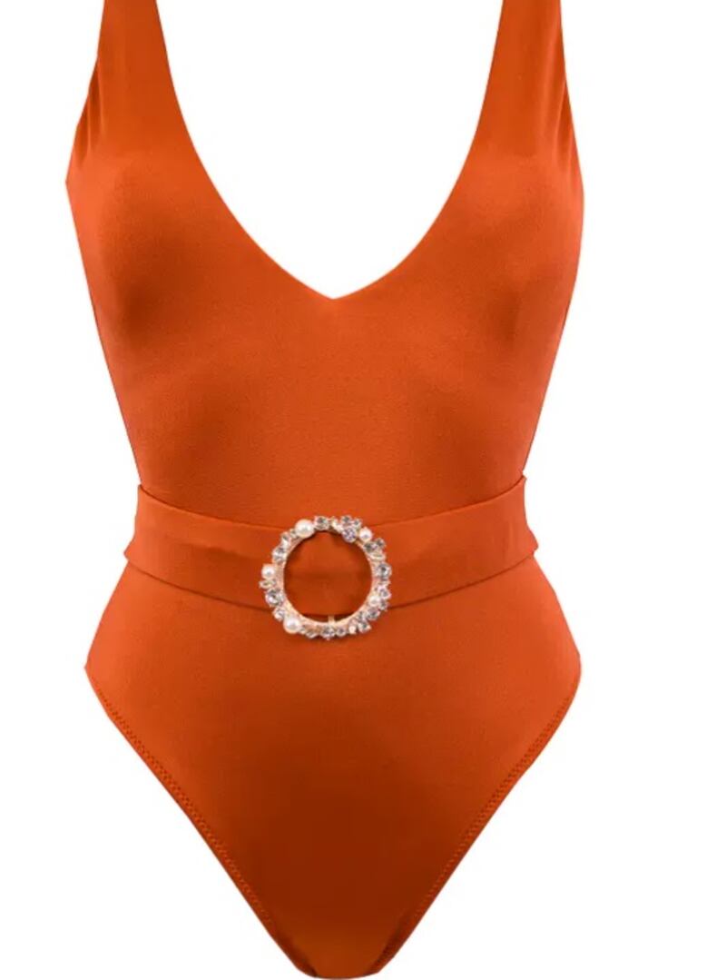 Belted swimsuits: evoking the same shade as a Bora Bora sunset, the orange Dora swimsuit by Lovekini features a rose gold crystal pearl embellished buckle on the belt; Dh606, Lovekini at sanddollardubai.com. Photo: Sand Dollar Dubai