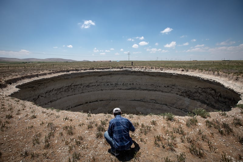 Geology Professor Fetullah Arik takes measurements next to a large sinkhole in Karapinar, Turkey. Getty Images