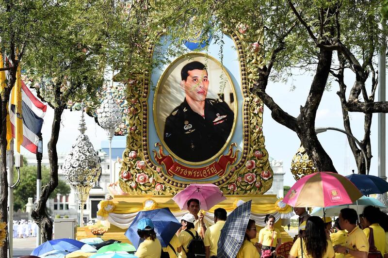 Well-wishers gather in front of a portrait of Thailand's King Maha Vajiralongkorn in Bangkok.  AFP