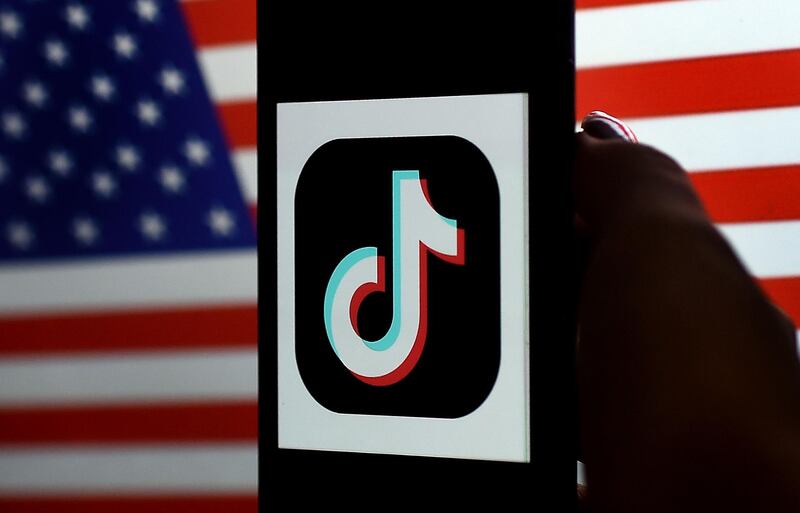In this photo illustration, the social media application logo, TikTok is displayed on the screen of an iPhone on an American flag background on August 3, 2020 in Arlington, Virginia.  President Donald Trump said Monday that Chinese-owned hugely popular video-sharing app TikTok will be "out of business" in the United States if not sold to a US firm by September 15, 2020."I set a date of around September 15, at which point it's going to be out of business in the United States," he told reporters. 
 / AFP / Olivier DOULIERY
