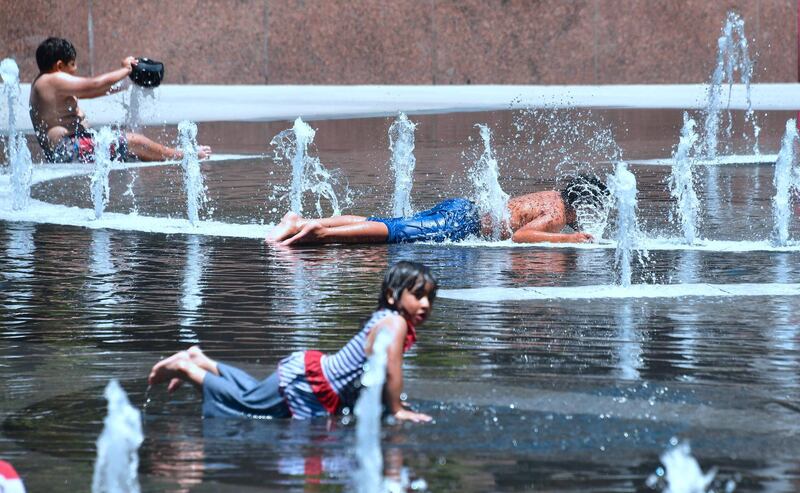 Children cool off in the water play area at Grand Park in Los Angeles, California on July 5, 2018 ahead of a coming heatwave in the Los Angeles area. / AFP / Frederic J. BROWN
