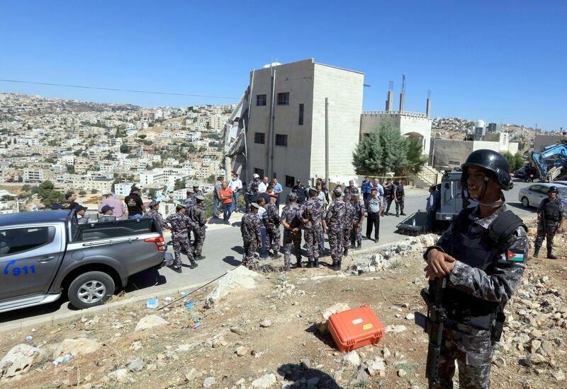 Jordanian security forces gather near a damaged building in the city of Salt, northwest of the capital Amman, on August 12, 2018. - Jordanian security forces have killed three "terrorists" and arrested five others during a raid after an officer was killed in a bomb blast near the capital, the government said. Three members of the security forces also died in Saturday's raid, which came after the home-made bomb exploded under a patrol car at a music festival. (Photo by Khalil MAZRAAWI / AFP)
