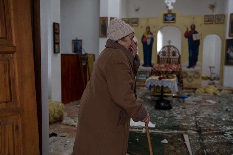 A visitor is in shock after returning to her church, which had come under Russian attack, in the Kyiv town of Makaro. AP