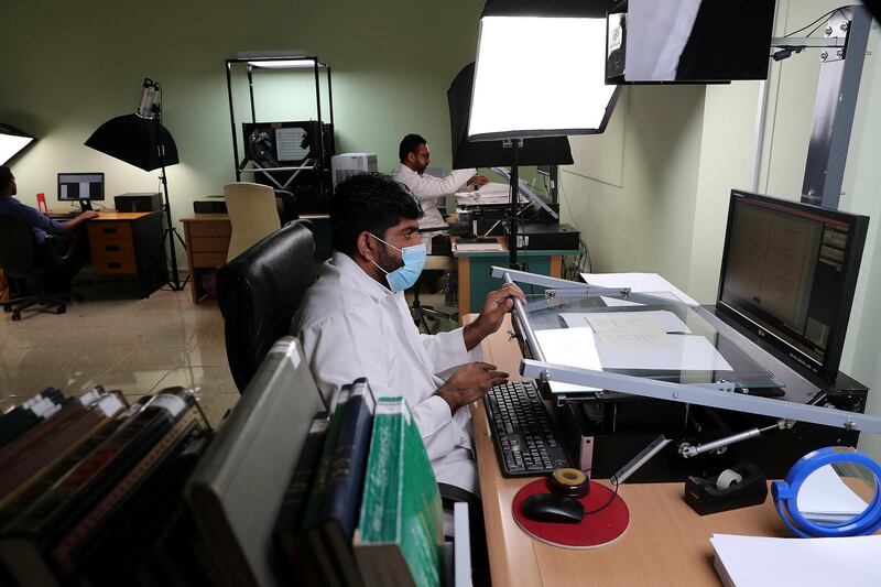 DUBAI , UNITED ARAB EMIRATES , FEB 20  – 2018 :- Workers scanning the book into digital format at the Juma Al Majid Centre for Culture and Heritage in Dubai. ( Pawan Singh / The National ) For Arts & Life. Story by Melissa Gronlund