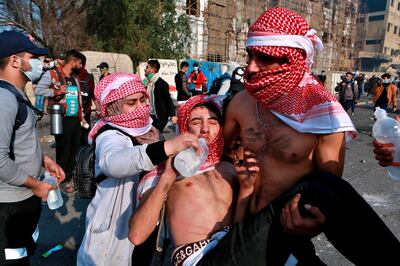 An injured protester receives first aid during clashes between security forces and anti-government protesters in central Baghdad, Iraq, Monday, Jan. 20, 2020. Iraqi security forces fired tear gas and live rounds on Monday wounding over a dozen protesters, medical and security officials said, in continuing violence as anti-government demonstrators make a push to revive their movement in Baghdad and the southern provinces. (AP Photo/Khalid Mohammed)