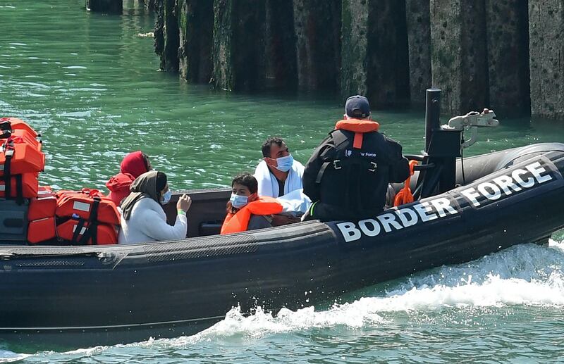 A Border Patrol dinghy brings a group of migrants, believed to have been picked up from boats in the Channel, into harbour at the port of Dover, on the south-east coast of England on August 9, 2020. The British government on Sunday appointed a former marine to lead efforts to tackle illegal migration in the Channel ahead of talks with France on how to stop the dangerous crossings. / AFP / Glyn KIRK
