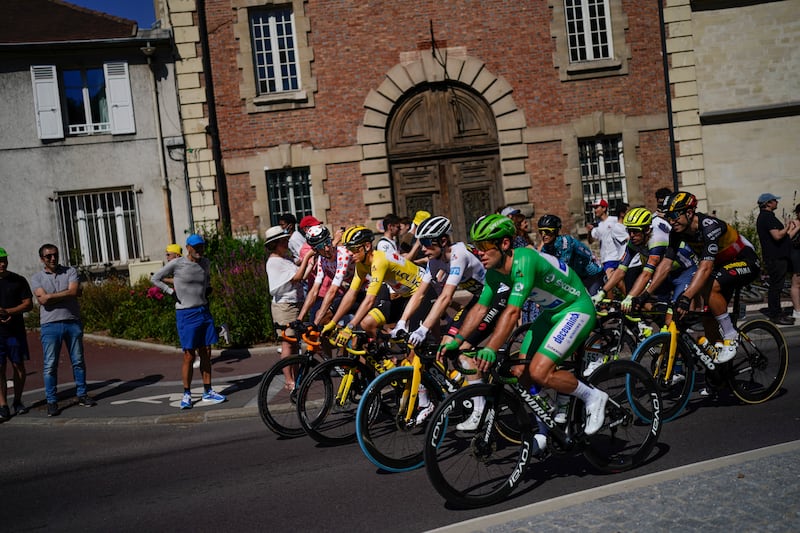 Slovenia's Tadej Pogacar, wearing the overall leader's yellow jersey, with the peloton during the neutral start of the 21st and last stage of the Tour de France.
